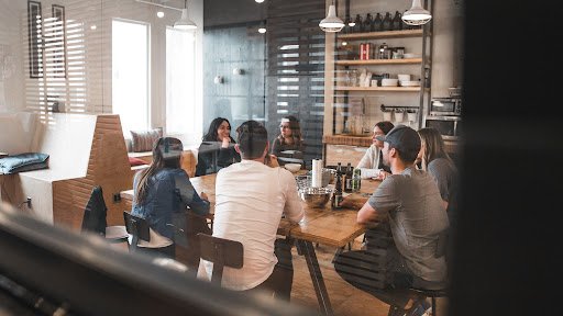 A group of young workers talking at a desk in an open spaced office